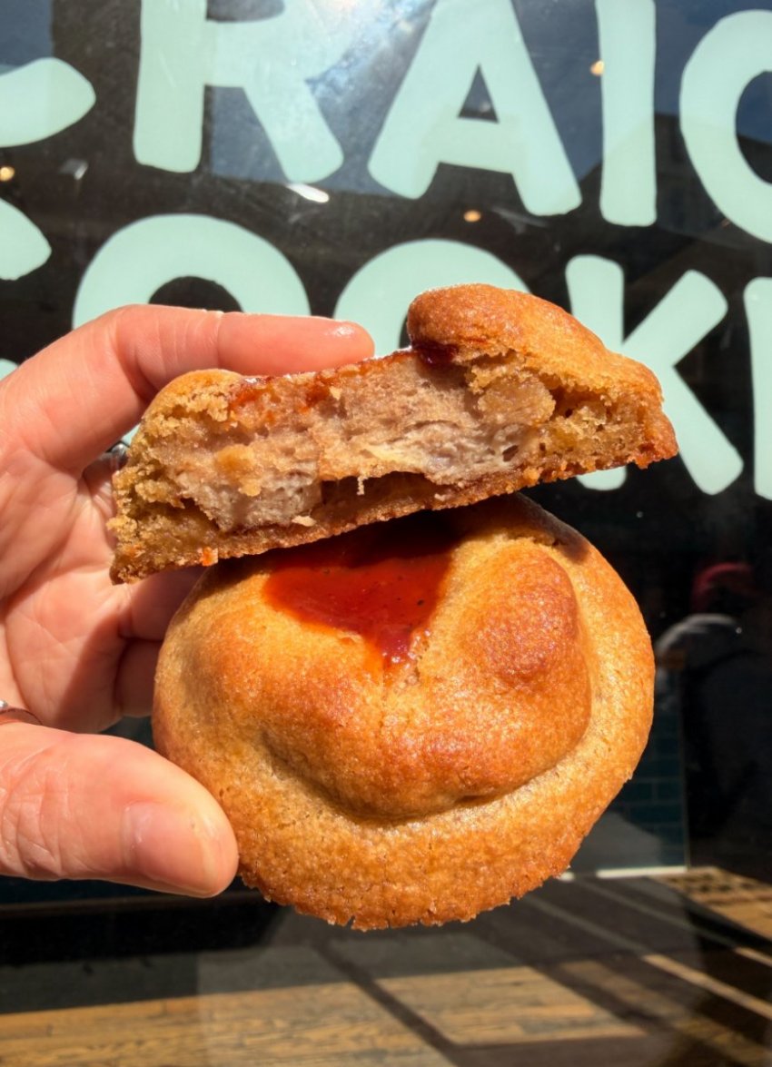 A thick chocolate chip cookie stuffed with a piece of savory smoky BBQ rib meat on a display platter.