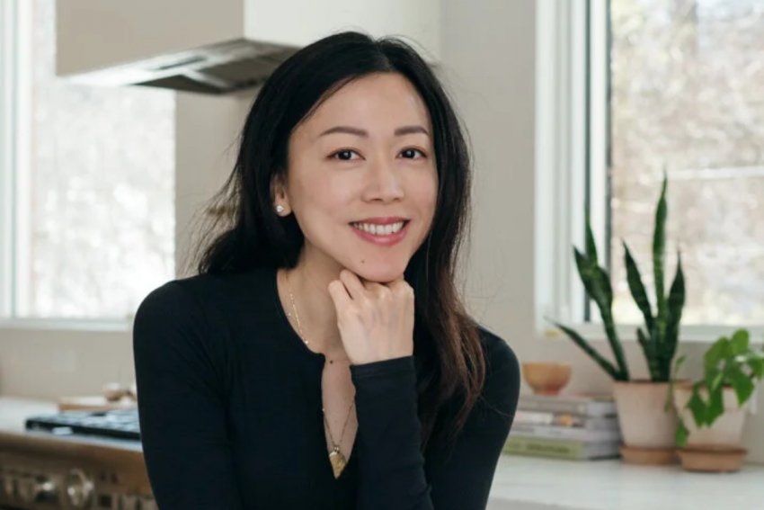 Sonia Wong of saltnpepperhere.com posing in her kitchen, leaning on a counter.