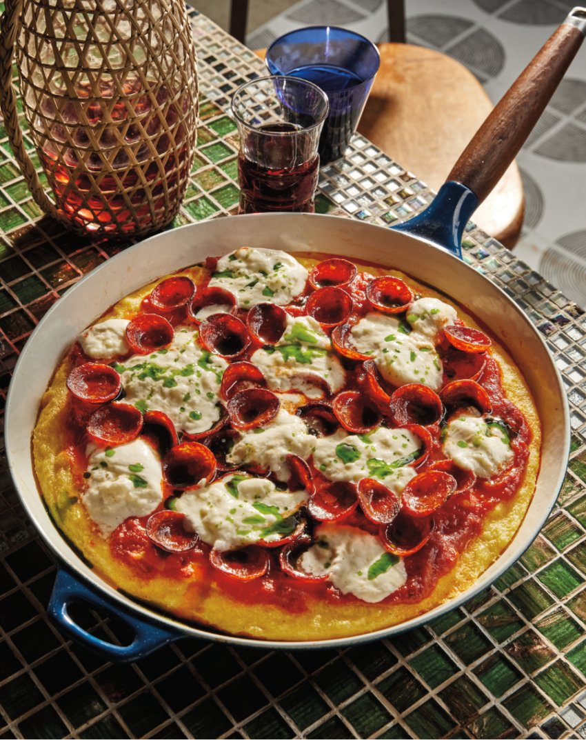 Portrait photo of pepperoni pizza polenta with melted burrata and fresh basil