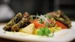 Wood fired root vegetables with winter squash, wild rice latke, pork belly and micro arugula. Photo by Kevin Kossowan.