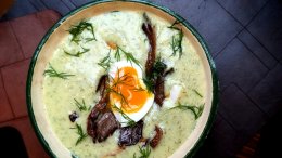 A landscape view of Dan Clapson’s Czech-style Kulajda mushroom soup garnished with fresh dill, crispy oyster mushrooms, and a jammy soft-boiled egg