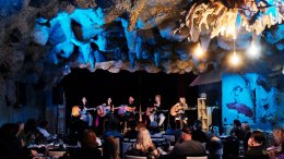 Blue Jay Sessions performers on stage at Blue Grotto Lounge in Hamilton with audience seated during a live songwriter circle.