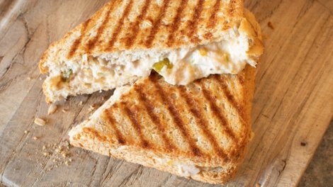 Grilled tuna melt sandwich with creamy filling and pickles on toasted bread