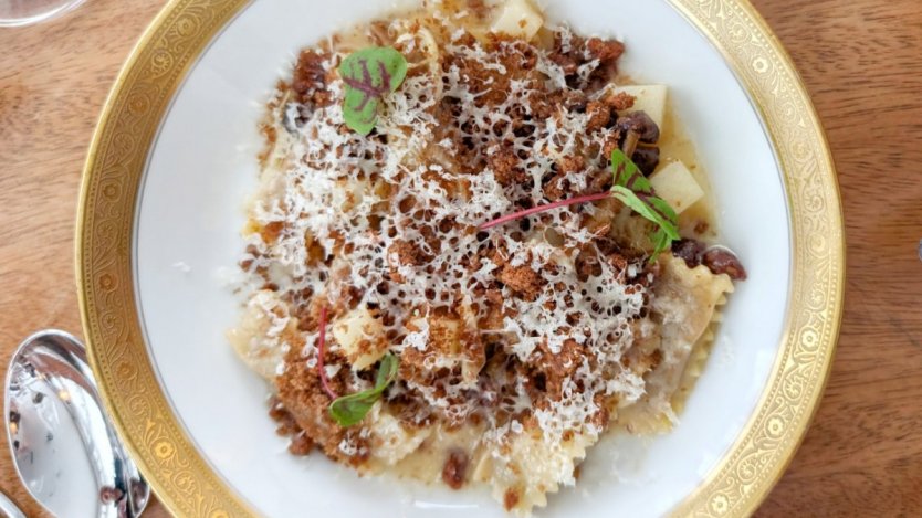 Photos of charred cabbage agnolotti by Dan Clapson. Charred cabbage agnolotti at Deane House in Calgary topped with rye breadcrumbs and Avonlea clothbound cheddar